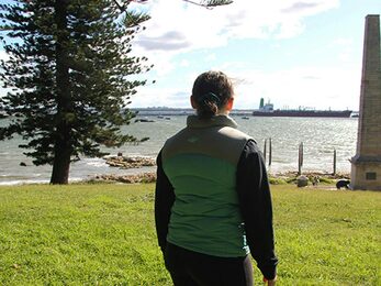 Girl looking out past Captain Cook Monument in Kurnell Kamay Botany Bay National Park Photo