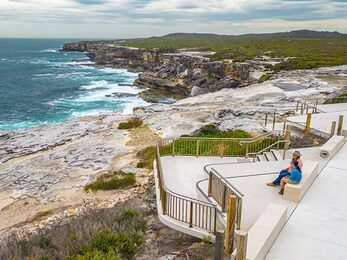 People looking out over the ocean from the whale watching platform at Cape Solander Photo John